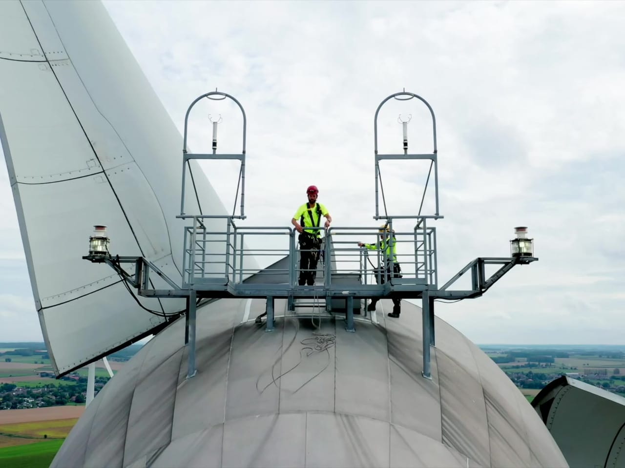 Deux techniciens sur la plateforme au sommet d'une éolienne