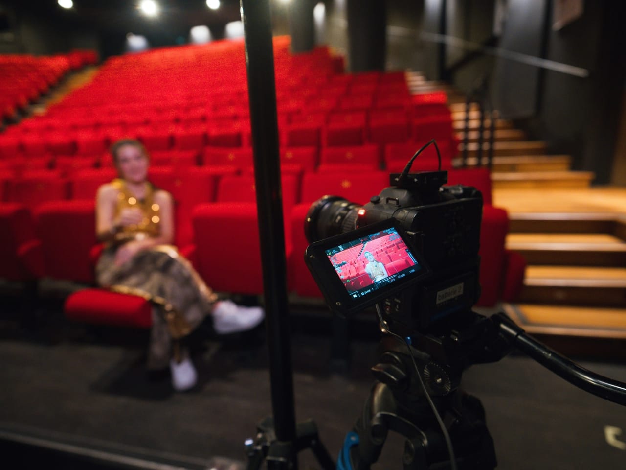 Interview filmée dans une salle de spectacle, caméra au premier plan
