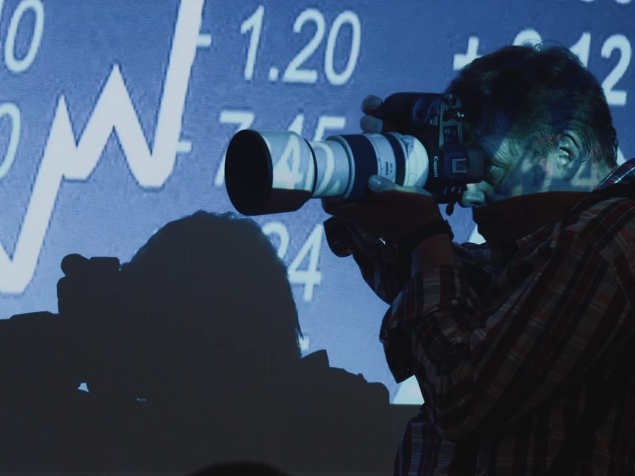 Photographe au téléobjectif pendant une conférence d'entreprise