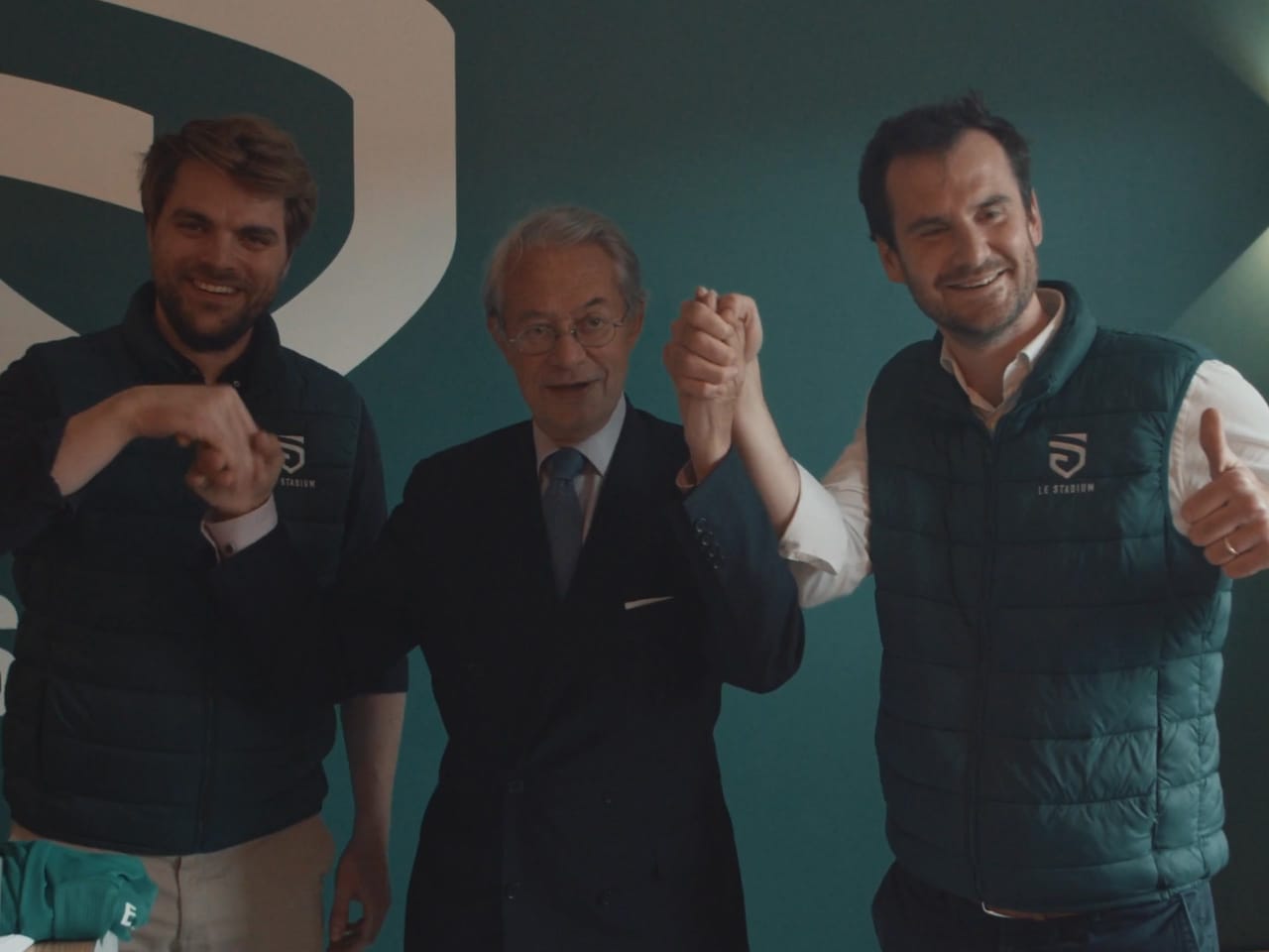 Les fondateurs du Stadium lèvent les bras avec un invité le soir de l'inauguration